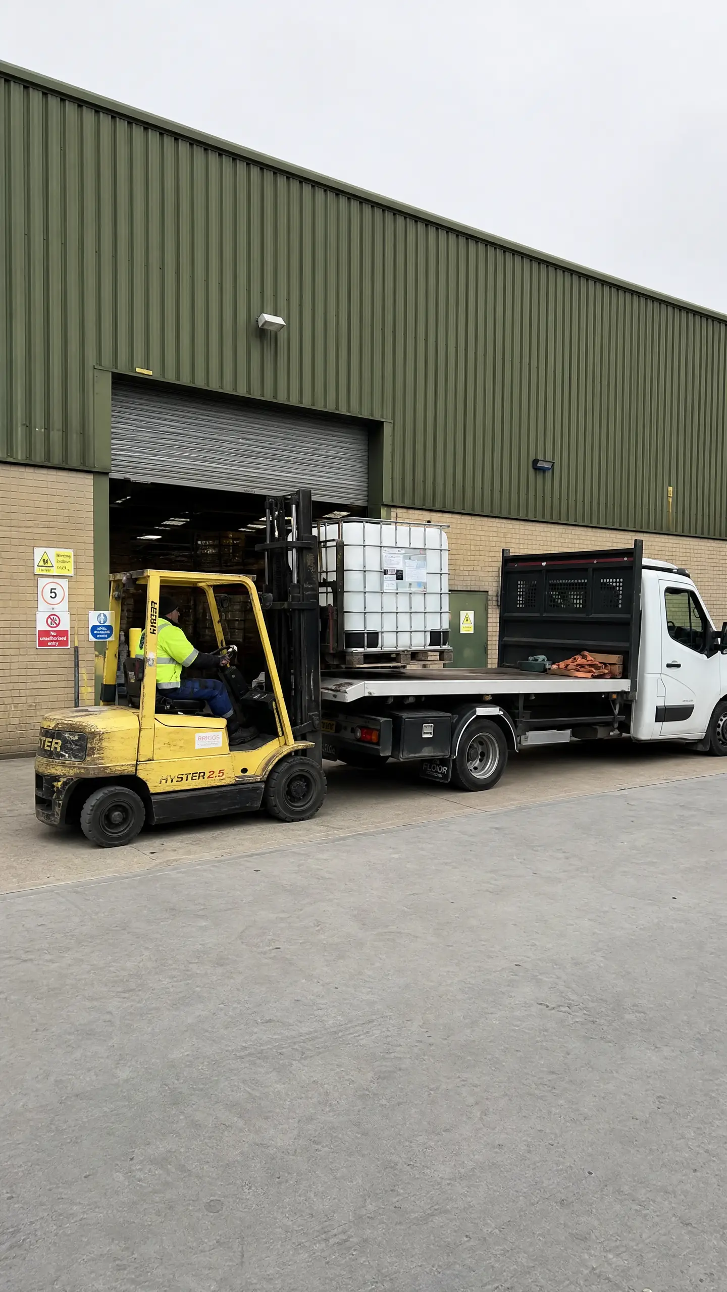 A forklift loading a van at a warehouse dock